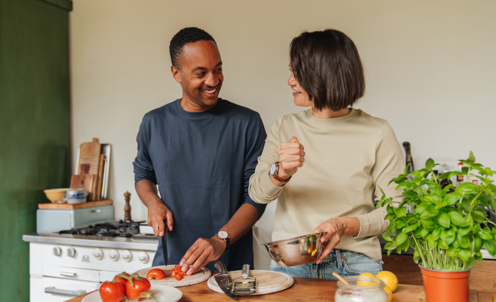 Couple laughing while cooking together Couple laughing while cooking together